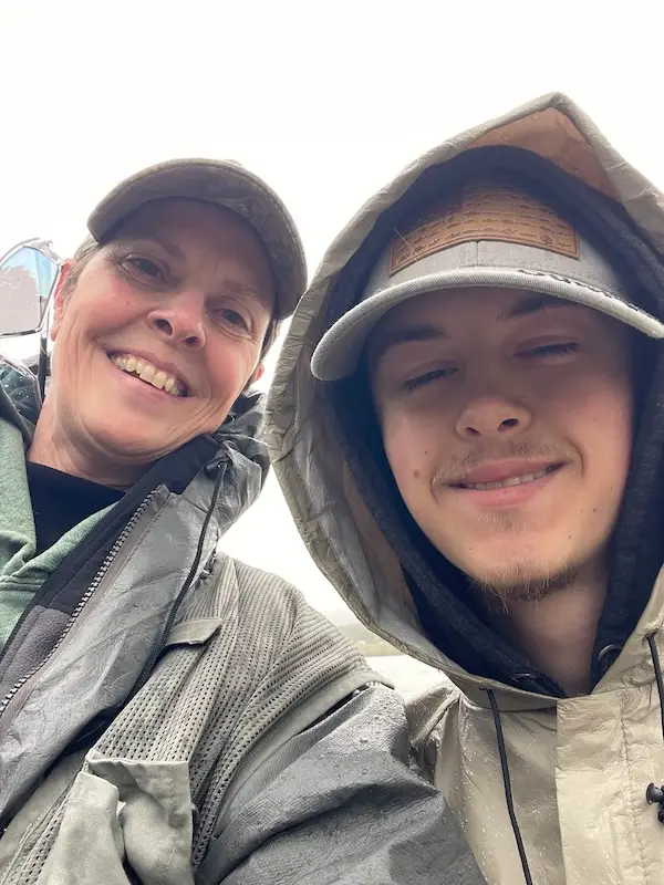 Amy and her grandson dressed in rain gear on a musky fishing trip, enjoying family connection and the joy of the outdoors.