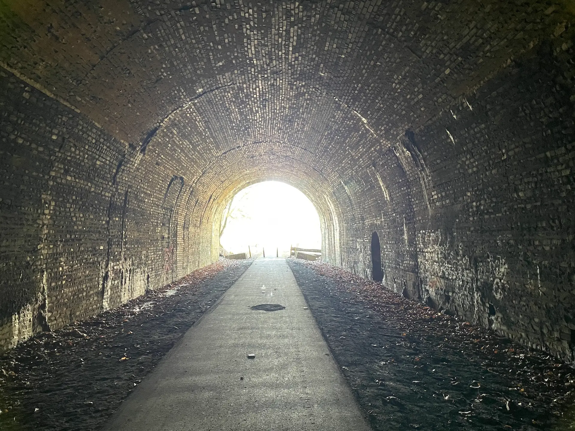 walking through a tunnel toward light symbolizing the journey of using personal development tools to find your life purpose